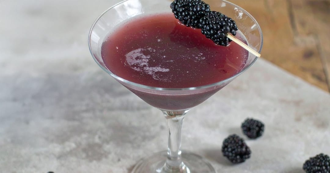 Simple blackberry martini is garnished with fresh blackberries
