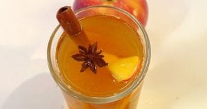 Best apple cider fireball is garnished with apple slices and cinnamon sticks