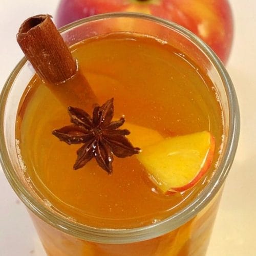 Best apple cider fireball is garnished with apple slices and cinnamon sticks