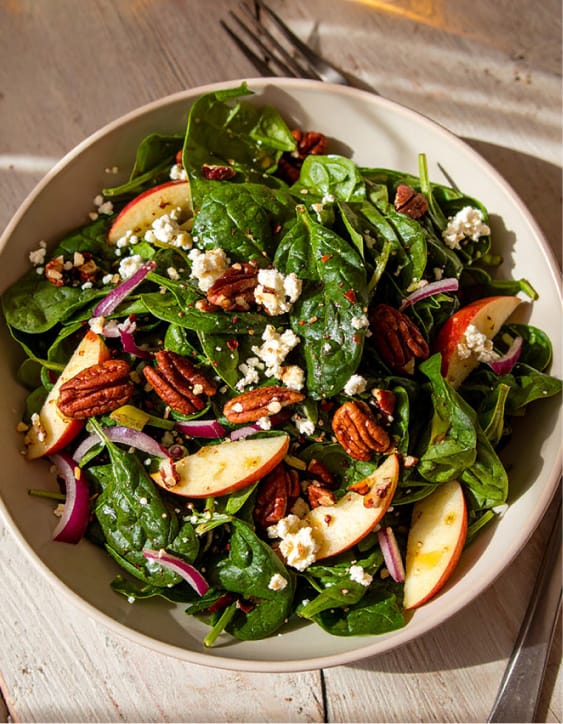Healthy spinach salad with apple, pecans, and feta
