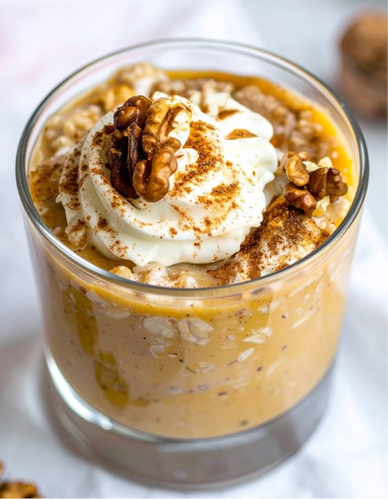 Pumpkin overnight oats topped with Greek yogurt and a scattering of walnuts and cinnamon