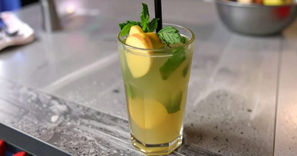 Apple Ginger Mojito garnished with apple slice, mint sprigs, and a thin slice of lime
