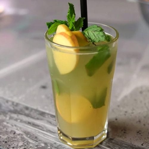 Apple Ginger Mojito garnished with apple slice, mint sprigs, and a thin slice of lime