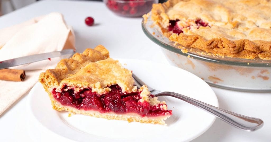A slice of cranberry pie with cranberry mixture filling