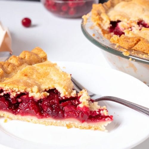 A slice of cranberry pie with cranberry mixture filling